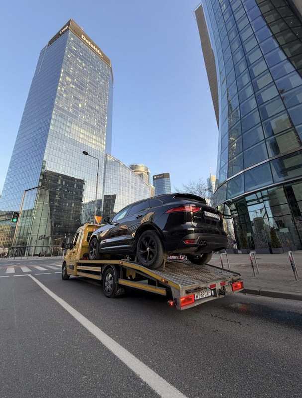 Holowanie Jaguara F-Pace lawetą w centrum Warszawy — biurowce Deloitte
